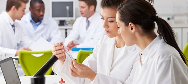 A team of lab professionals reviewing a sample